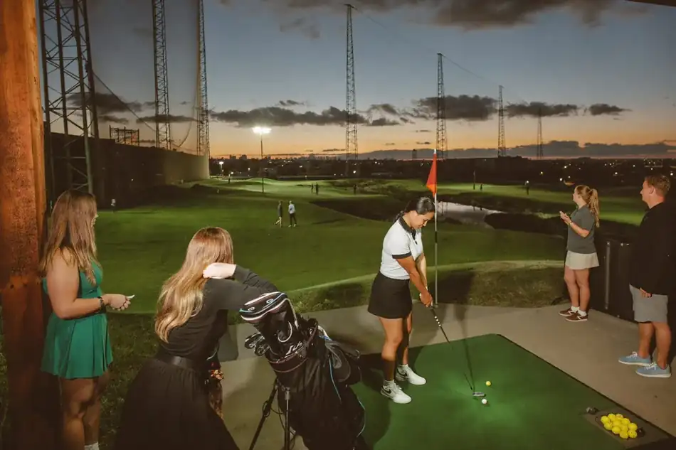 Golfers spending an evening practicing at the range