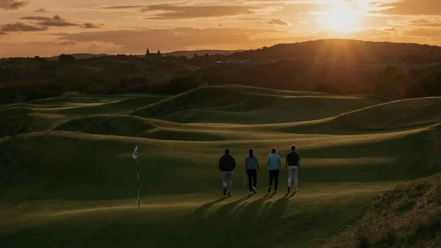 Friends walking the golf course as the sun sets